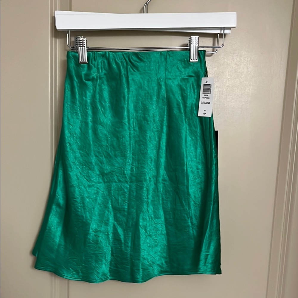 Babaton gloss Green Satin Skirt. The color is more vibrant and shiny.